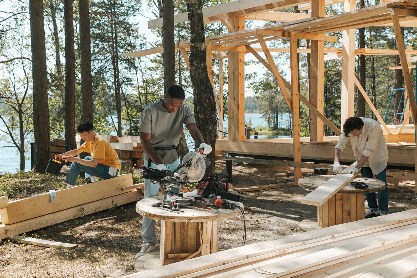 Small crew of tradespeople cutting and preparing timber on an outdoor worksite